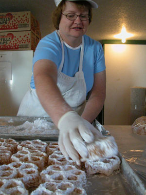 &nbsp;&nbsp;Dianna Ireton places another delicious waffle on the tray after rolling it in powdered sugar early this morning in the Knights of Columbus building at the Mercer County Fair. Center photo, other K of C volunteers, Dick Colson (at right) and Carl Deitsch, fry up the sweet creations three at a time.<br>&nbsp;&nbsp;<br>dailystandard.com