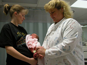 &nbsp;&nbsp;Tina Brunswick of Coldwater holds her third child, Emily, as Registered Nurse Anne Opperman takes a look at the infant's Hugs security bracelet. The bracelets are part of a software security program that tracks the location of each newborn at Mercer County Community Hospital, Coldwater.<br></br>dailystandard.com